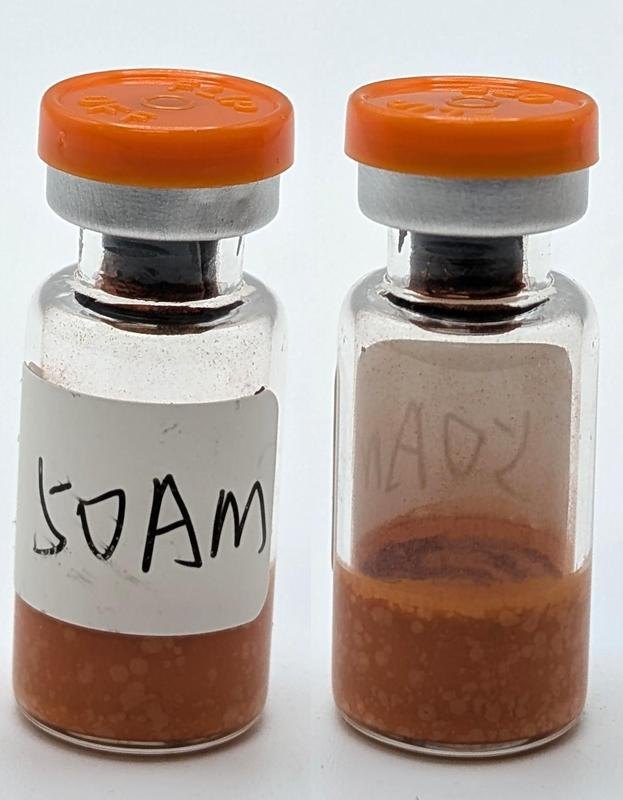 Two vials of 5-Amino-1MQ 50 mg with orange flip caps, containing a rust-orange lyophilised cake